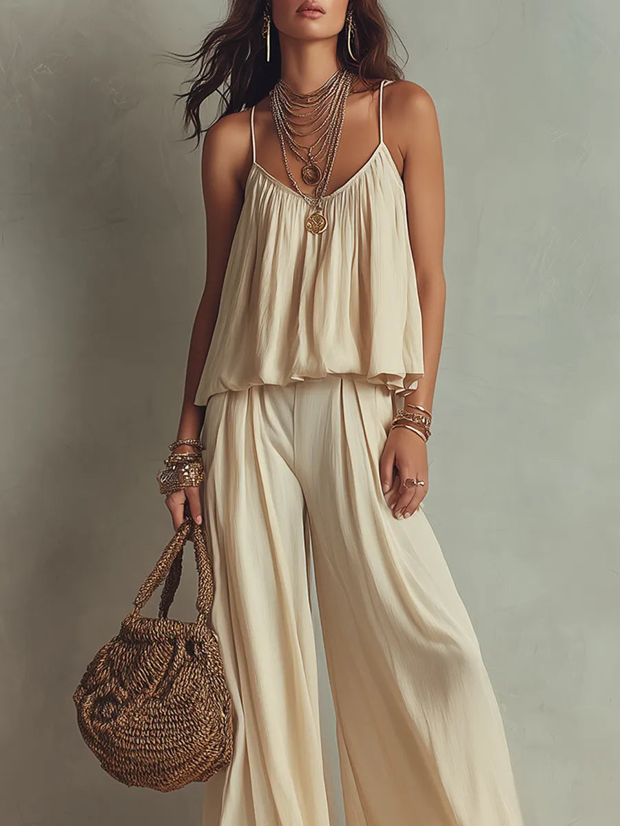 An Off White Flowing Top Paired With Thin Straps And Wide Leg Pants